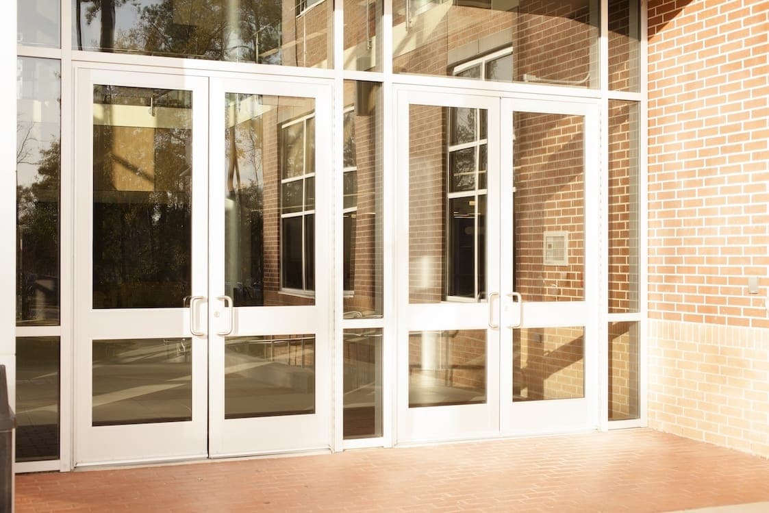 Row of white FRP entry doors on an office building storefront