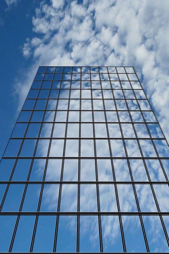 Upward view of a glass office building against the sky